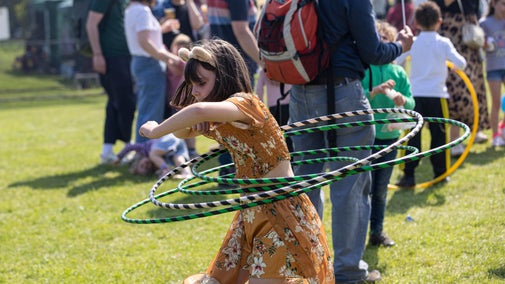 A girl doing hula hoops, taking part in a circus workshop